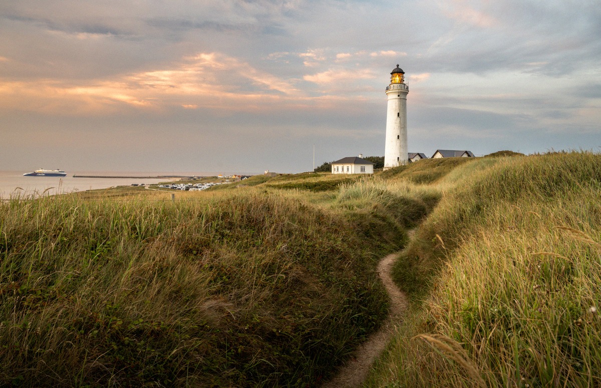 O farol de Hirtshals, na costa norte da Dinamarca, com um ferry ao fundo. É daqui que o Norröna parte para a sua travessia até à Islândia.