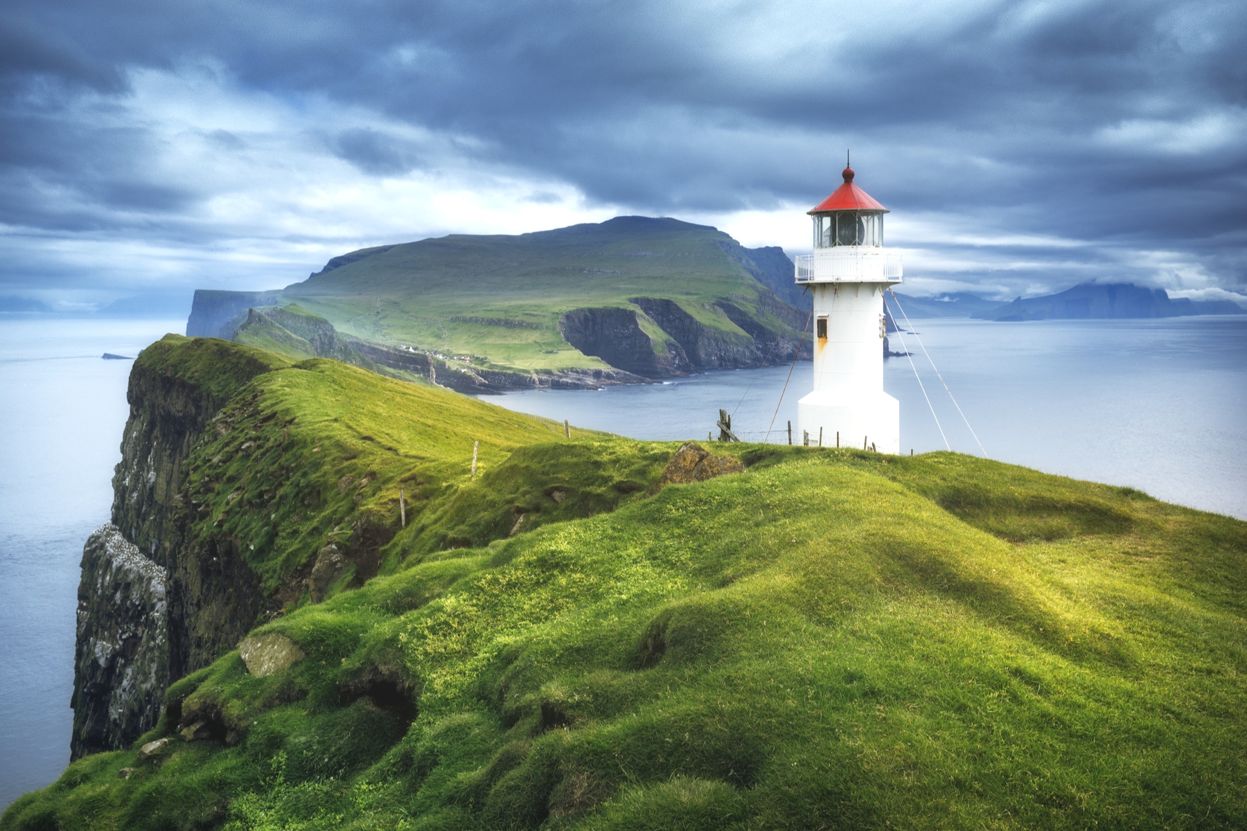 Dramatic cliff scenery in the Faroe Islands near the Mykines lighthouse. The archipelago is easy to explore by car from Tórshavn.